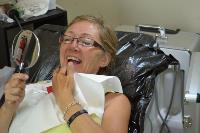 Dental patient inspects teeth in mirror